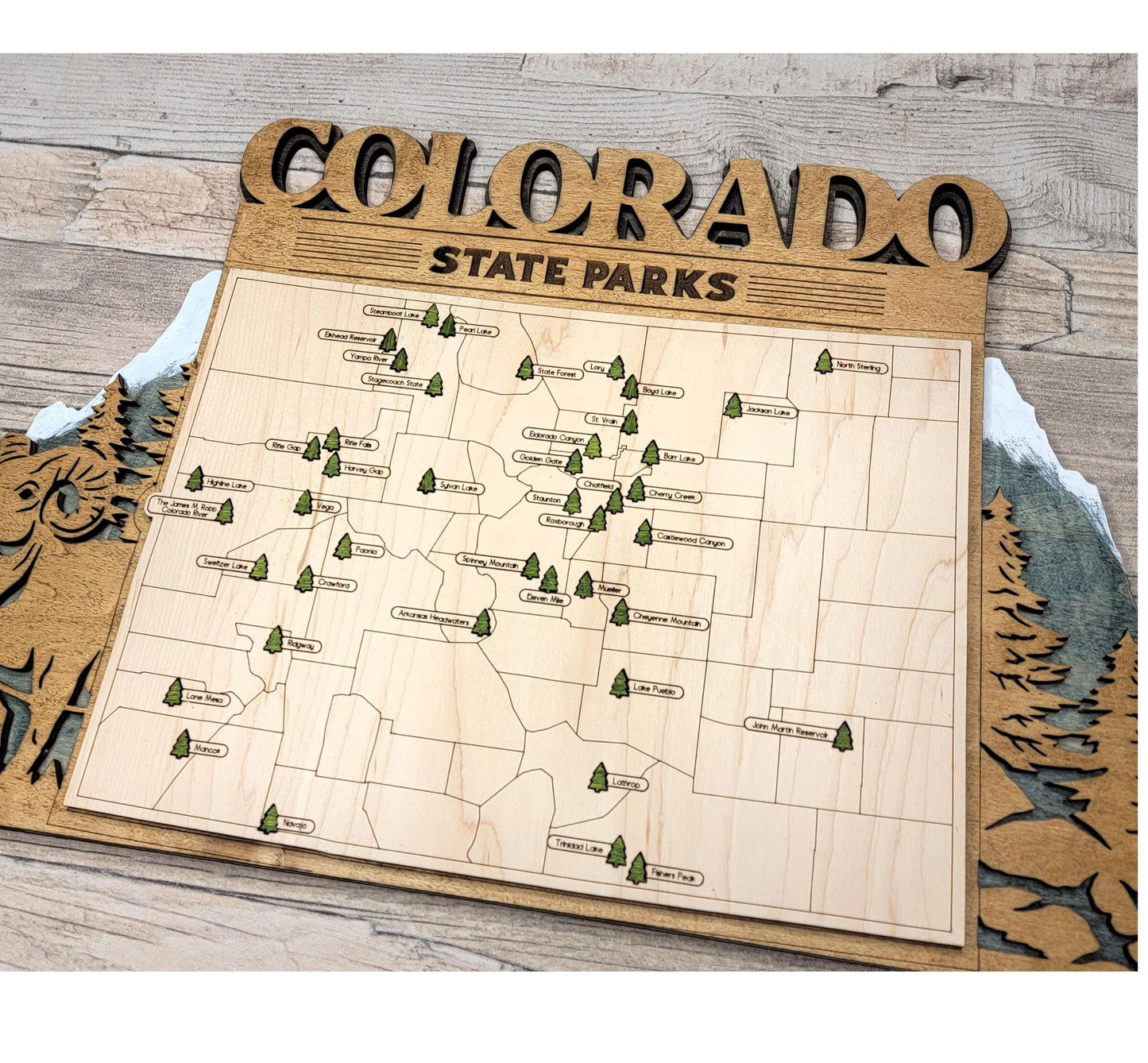 Wooden Colorado State Park map hanging on wall, rustic engraved travel and adventure decor