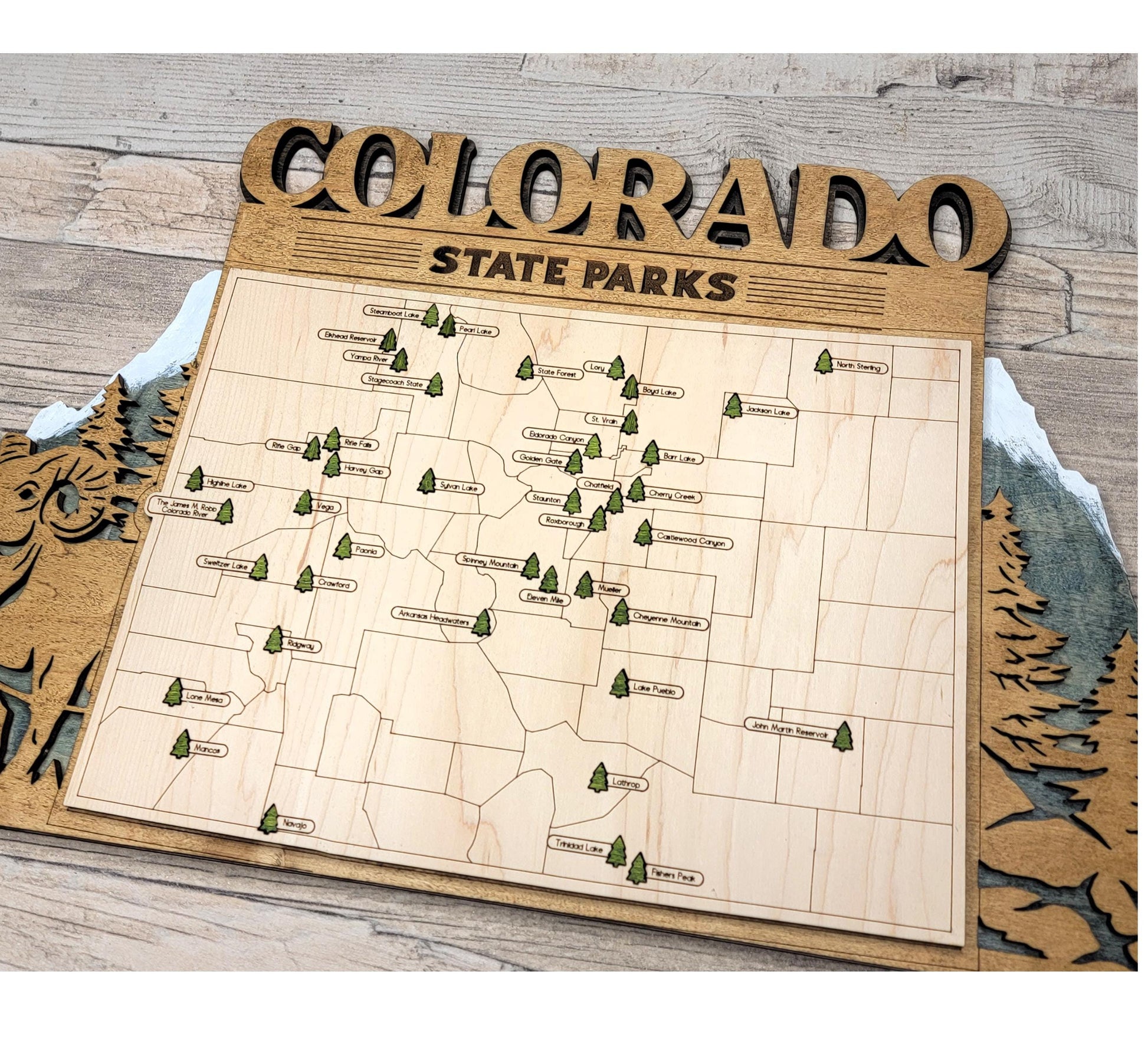 Wooden Colorado State Park map hanging on wall, rustic engraved travel and adventure decor