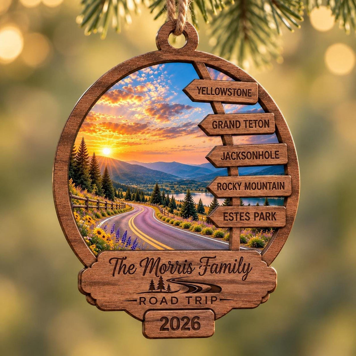 A custom wooden Christmas ornament featuring a sunset road trip graphic, stacked destination signs for Yellowstone, Grand Teton, Jackson Hole, Rocky Mountain, and Estes Park, engraved with The Morris Family Road Trip 2026.