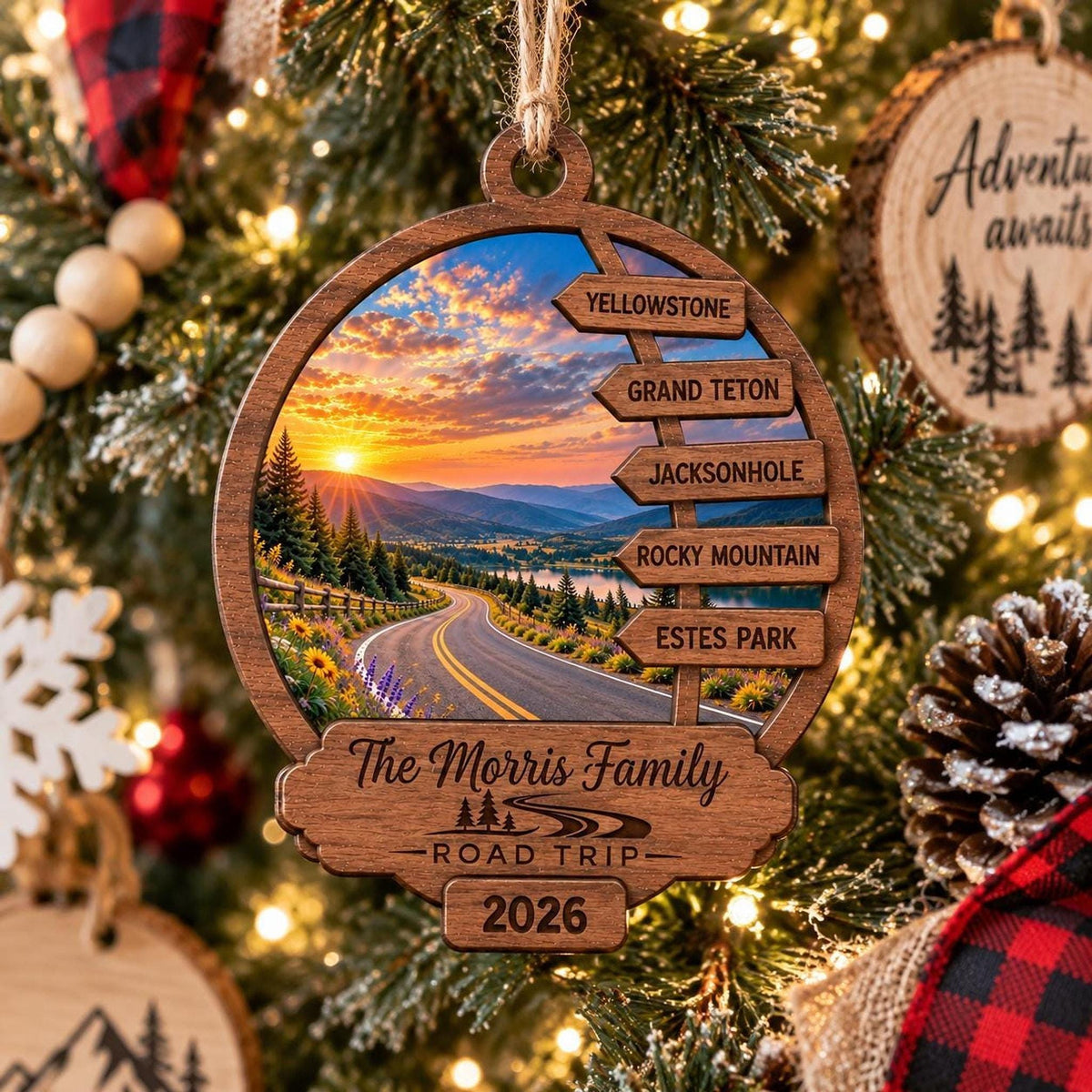 The wooden road trip ornament hangs on a lit Christmas tree decorated with pinecones and ornaments.
